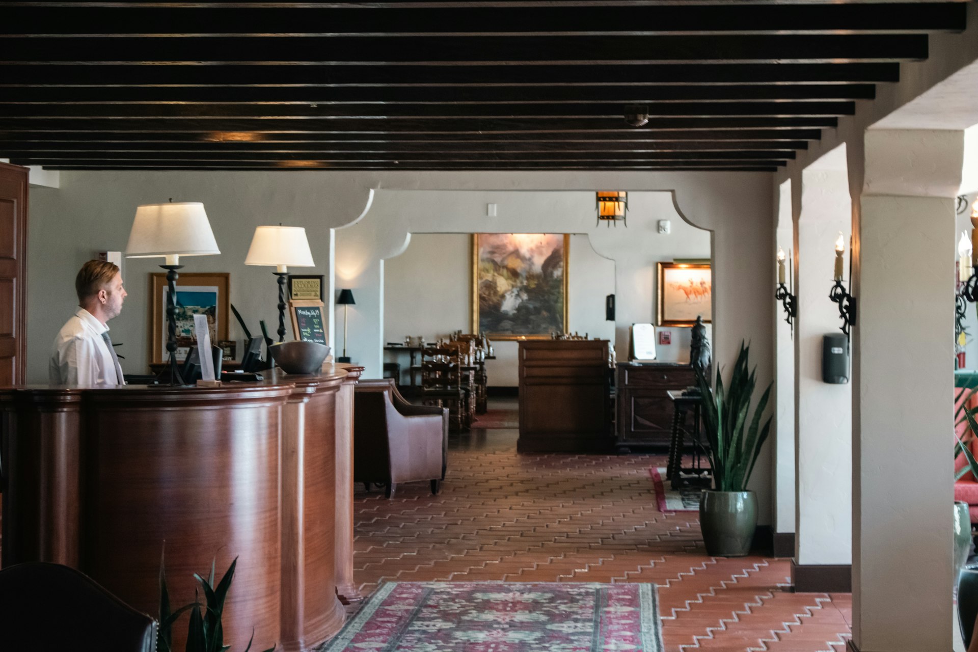 A woman standing at the front desk of a hotel reception